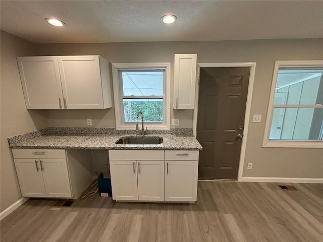 2489 Hillside Dr, Macon, GA 31206 - kitchen featuring a sink, wood finished floors, baseboards, white cabinetry, and recessed lighting