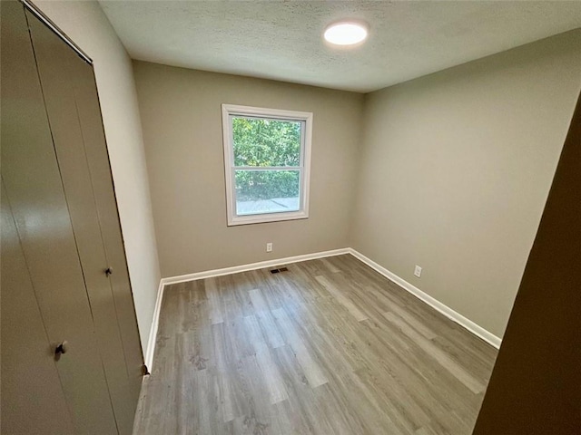 2489 Hillside Dr, Macon, GA 31206 - unfurnished bedroom featuring wood finished floors, baseboards, a closet, and a textured ceiling