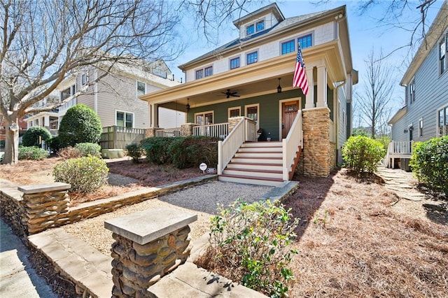 traditional style home with a porch, ceiling fan, and stairs