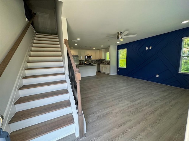 stairway featuring wood finished floors, recessed lighting, and ceiling fan