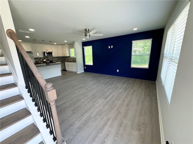 unfurnished living room featuring recessed lighting, stairway, visible vents, a ceiling fan, and light wood-type flooring