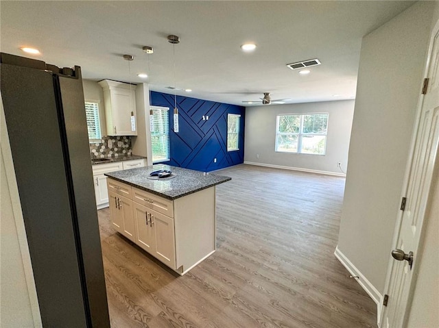 kitchen with wood finished floors, visible vents, white cabinetry, freestanding refrigerator, and ceiling fan