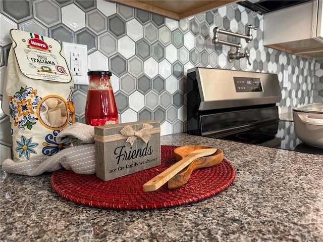 room details with stainless steel range with electric cooktop, dark countertops, and range hood