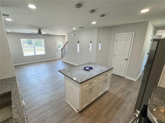 kitchen featuring visible vents, a ceiling fan, dark wood-style floors, and white cabinetry