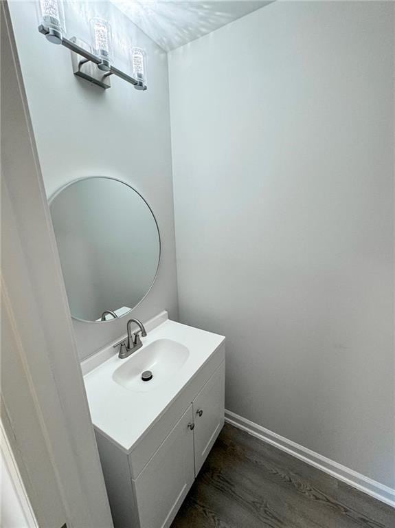 bathroom with baseboards, wood finished floors, and vanity