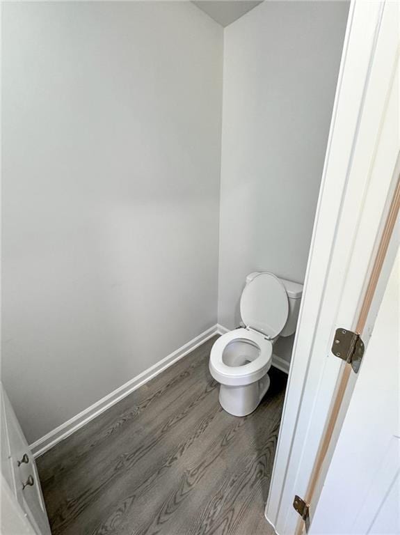 bathroom featuring wood finished floors, toilet, and baseboards