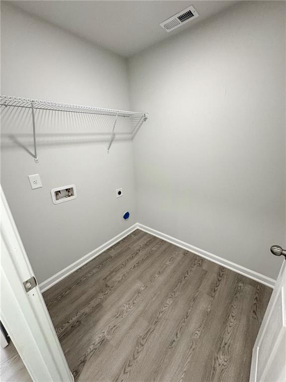 washroom with laundry area, wood finished floors, visible vents, hookup for a washing machine, and electric dryer hookup