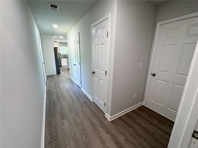 hall featuring baseboards, visible vents, recessed lighting, and dark wood-style flooring