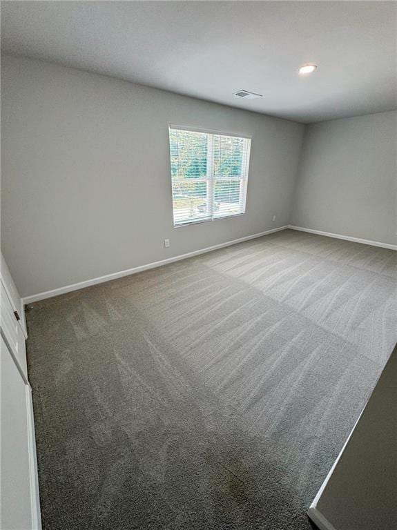 carpeted empty room featuring recessed lighting, visible vents, and baseboards