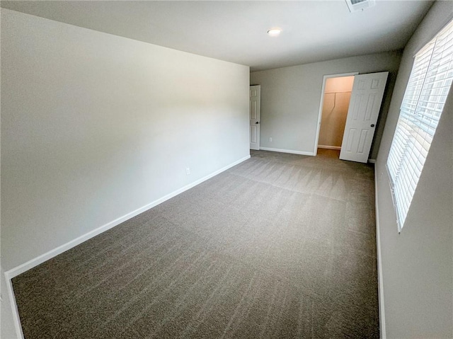 unfurnished bedroom with a spacious closet, carpet floors, a closet, and baseboards