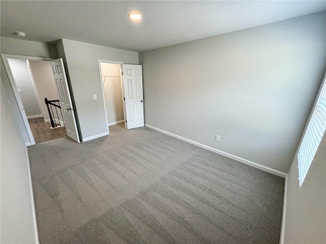 unfurnished bedroom with a closet, carpet flooring, and baseboards