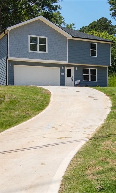 view of front of house featuring a garage, a front lawn, and concrete driveway