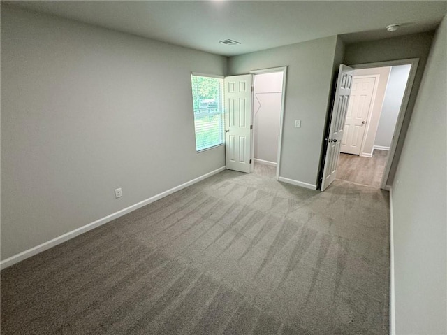 unfurnished bedroom with carpet, visible vents, and baseboards