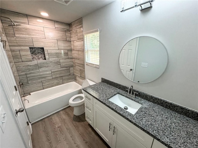 bathroom featuring recessed lighting, bathing tub / shower combination, wood finished floors, toilet, and vanity