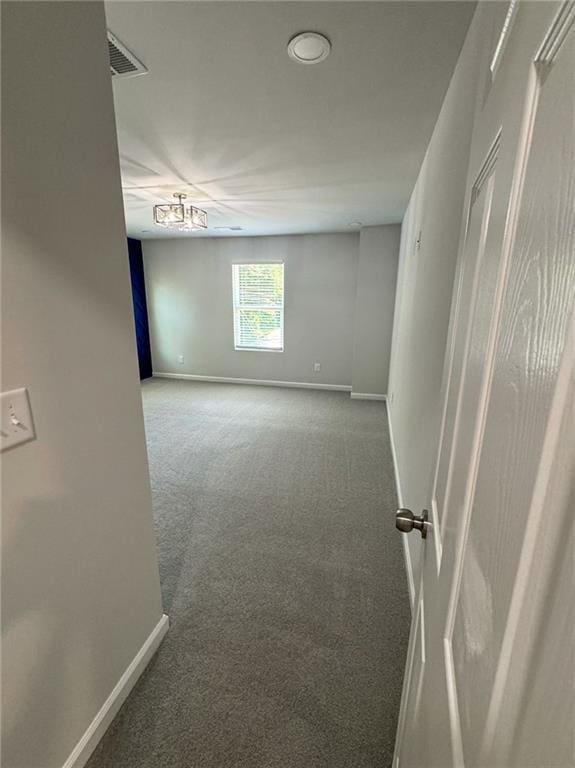 empty room featuring carpet floors, visible vents, and baseboards