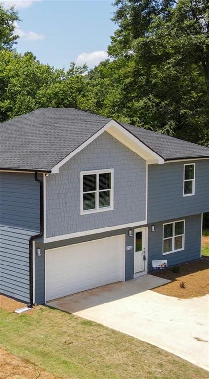 1351 E Atlanta Rd E, Stockbridge, GA 30281 - view of front facade with concrete driveway, a garage, a shingled roof, and a front yard