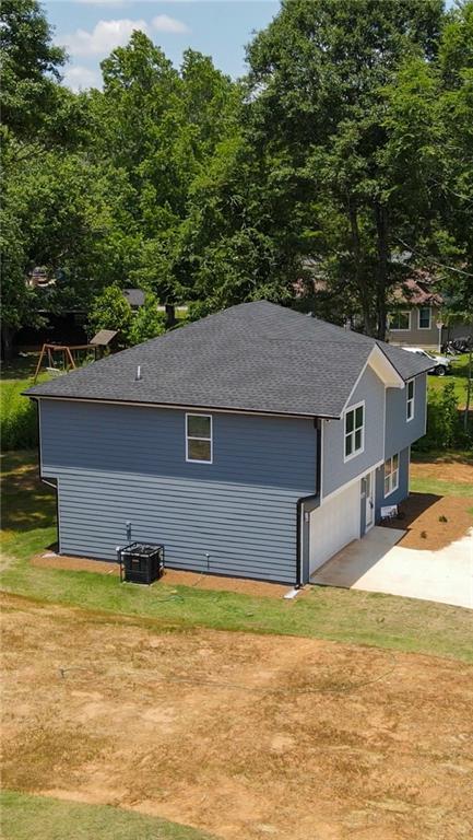 exterior space featuring concrete driveway and central air condition unit