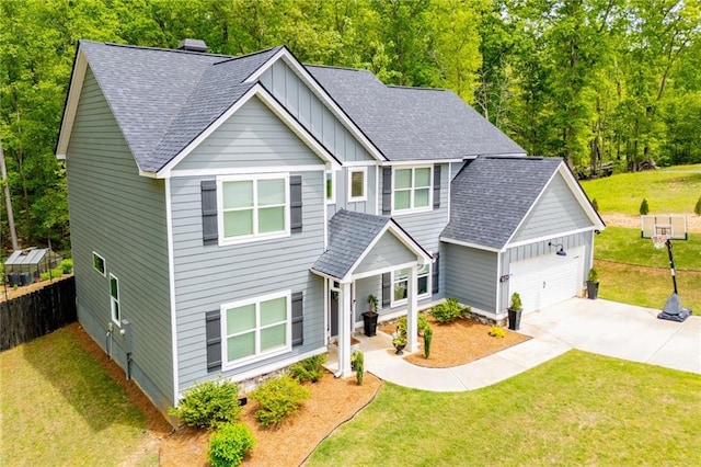 craftsman-style home with a shingled roof, board and batten siding, and a front lawn