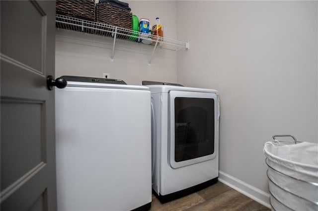 laundry room with laundry area, baseboards, dark wood-style flooring, and washer and dryer