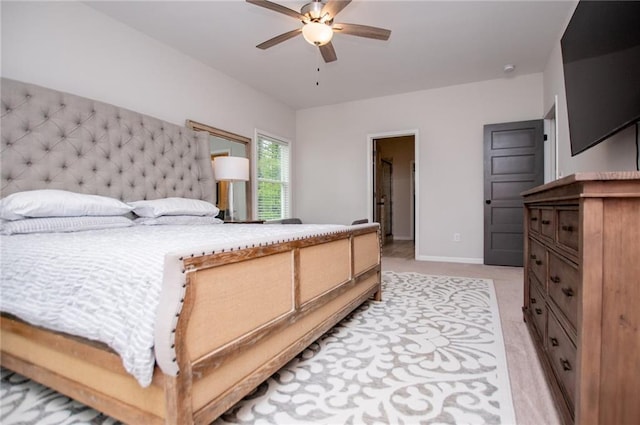 bedroom with light colored carpet, baseboards, and ceiling fan