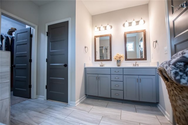 full bath featuring a sink, baseboards, and double vanity