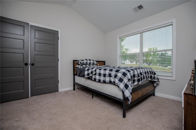 bedroom featuring carpet flooring, baseboards, visible vents, and lofted ceiling
