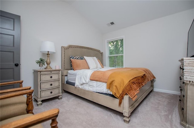 bedroom featuring visible vents, baseboards, lofted ceiling, and light carpet
