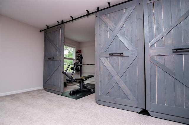 interior space with baseboards, a barn door, and carpet