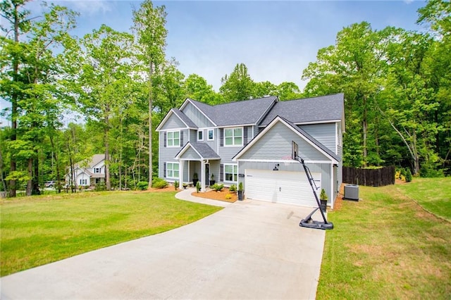 craftsman inspired home featuring a front lawn, fence, board and batten siding, central air condition unit, and driveway