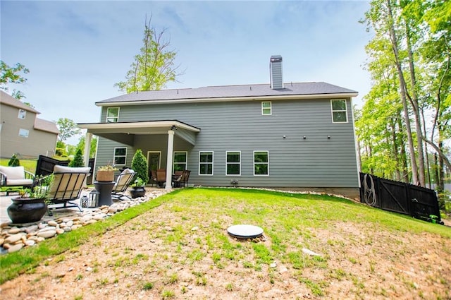 back of house featuring fence, a patio, a chimney, and a yard