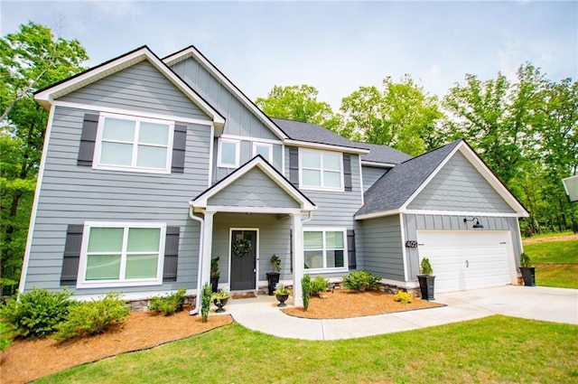 view of front of home with a garage, board and batten siding, a front yard, and concrete driveway
