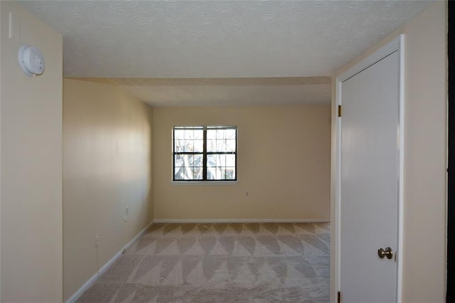 carpeted empty room with a textured ceiling