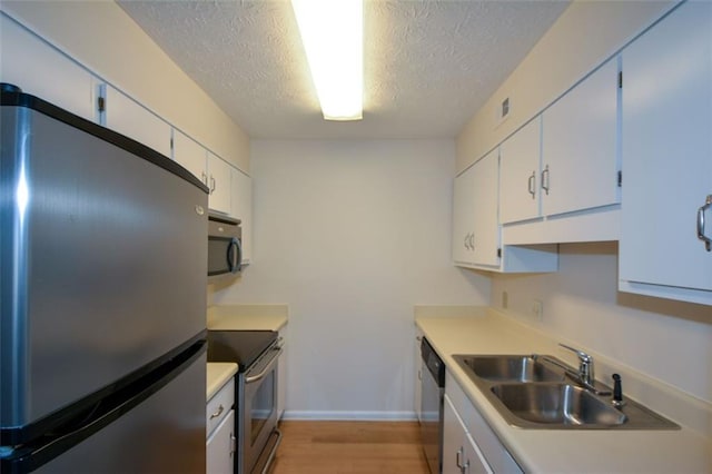 kitchen featuring white cabinets, a textured ceiling, and appliances with stainless steel finishes