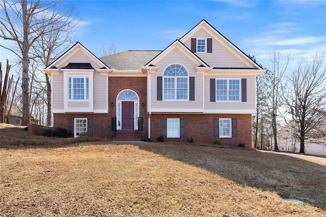 bi-level home featuring brick siding and a front lawn