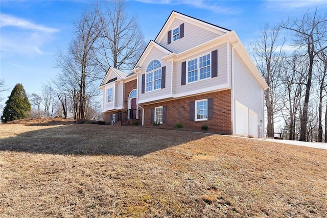 view of front of property featuring a garage, driveway, and brick siding