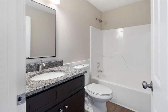 full bathroom featuring washtub / shower combination, vanity, toilet, and wood finished floors