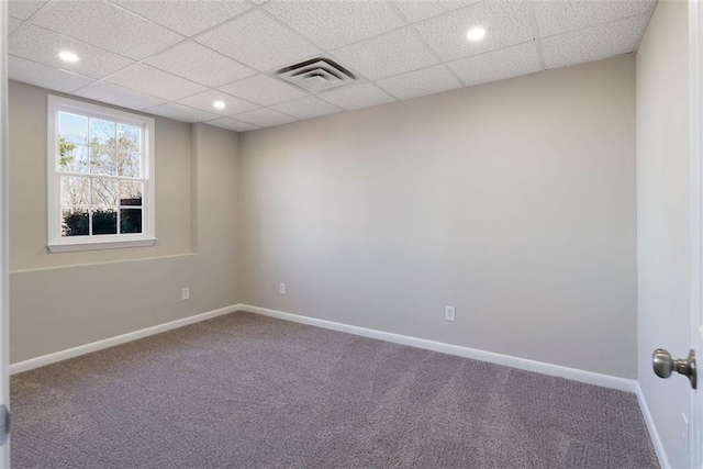 carpeted spare room featuring baseboards, visible vents, a drop ceiling, and recessed lighting