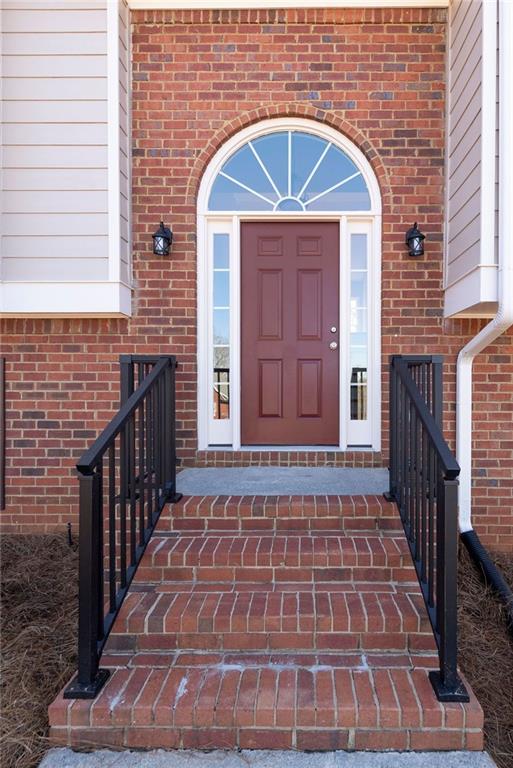 doorway to property with brick siding