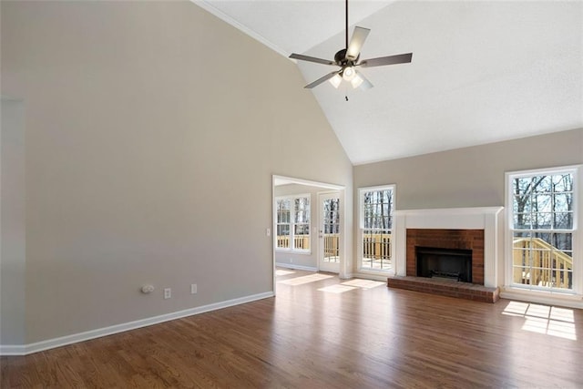 unfurnished living room featuring a ceiling fan, a fireplace, baseboards, and wood finished floors