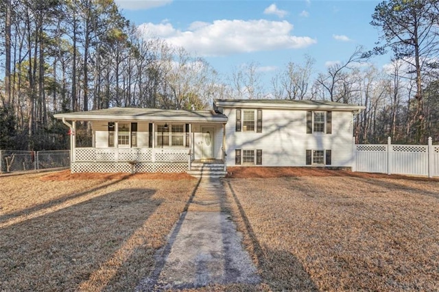 split level home with covered porch and fence