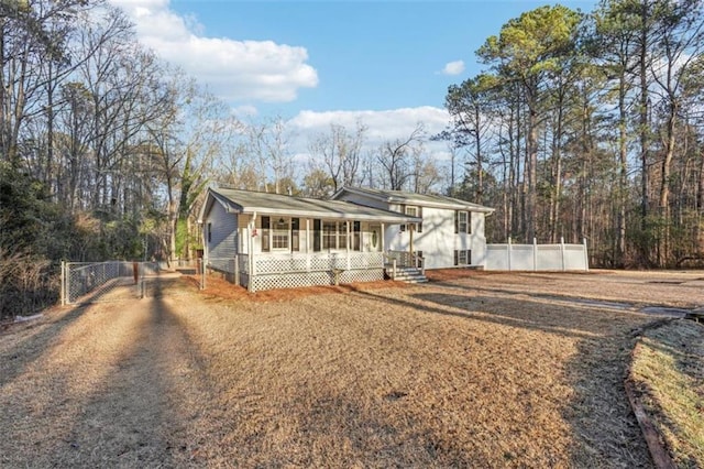 view of front of property with driveway, a porch, fence, and a gate