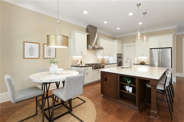 385 Windy Pines Trl, Roswell, GA 30075 - kitchen featuring wall chimney exhaust hood, appliances with stainless steel finishes, backsplash, a kitchen island with sink, and crown molding