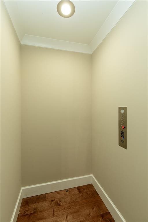 385 Windy Pines Trl, Roswell, GA 30075 - spare room featuring baseboards, dark wood finished floors, elevator, and crown molding