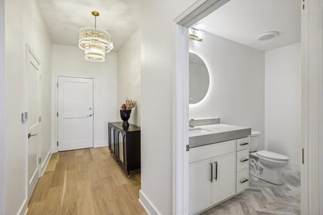 interior space featuring sink, light wood-type flooring, and a chandelier