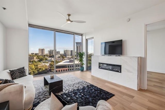 living room featuring light hardwood / wood-style floors, ceiling fan, and floor to ceiling windows