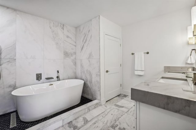 bathroom with vanity, tile walls, and a bathing tub