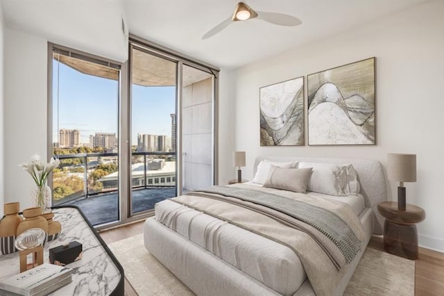 bedroom with floor to ceiling windows, ceiling fan, multiple windows, and access to exterior