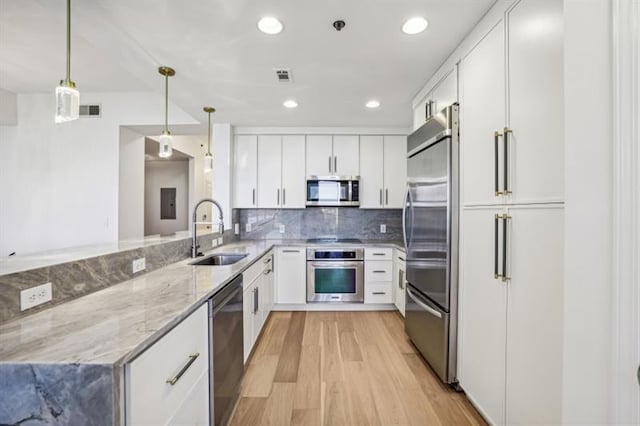 kitchen with sink, stainless steel appliances, and white cabinetry