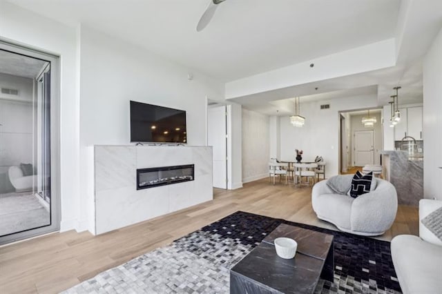 living room with ceiling fan, hardwood / wood-style floors, and a fireplace