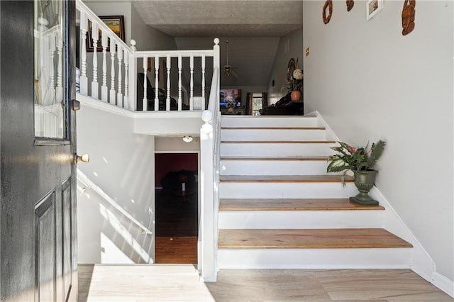 stairs with visible vents and wood finished floors